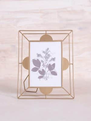 Brass scallop-edged 5x7 photo frame with wire stand, featuring botanical artwork.