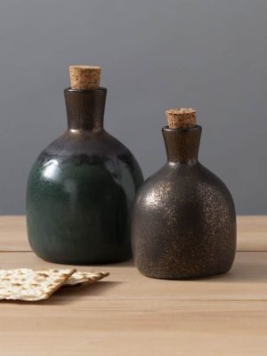 Olive Oil Bottle Set with ceramic bottles in copper and greenc glazes, styled on a wooden table