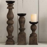 A collection of three Hand-Turned Pillar Candle Holders in varying sizes, featuring a rustic wooden design and black metal candle holders.