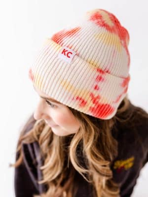 Close-up of Red & Yellow Watercolor KC Beanie with bold KC cuff tag.