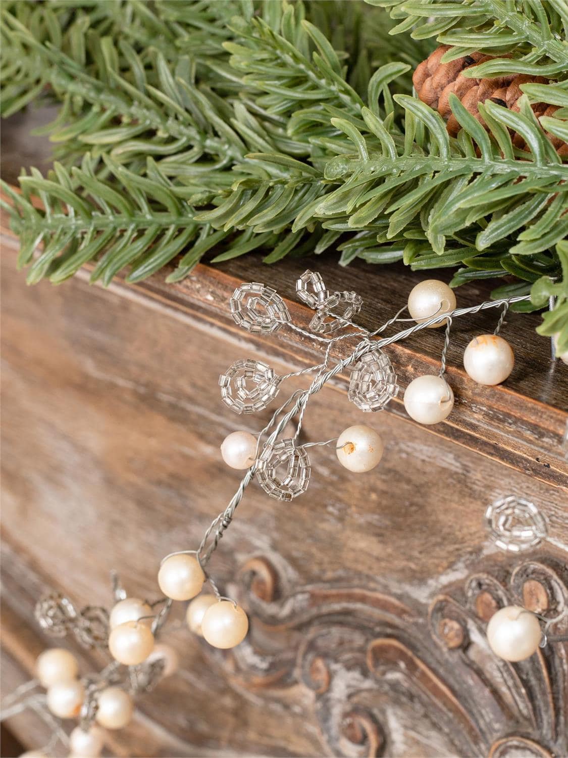 Close-up of metallic bead garland woven through faux pine greenery.