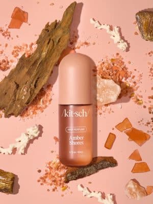 Amber Shores Hair Perfume bottle displayed with listed fragrance notes: wild orchid, kumquat, lemon, black amber, and driftwood.