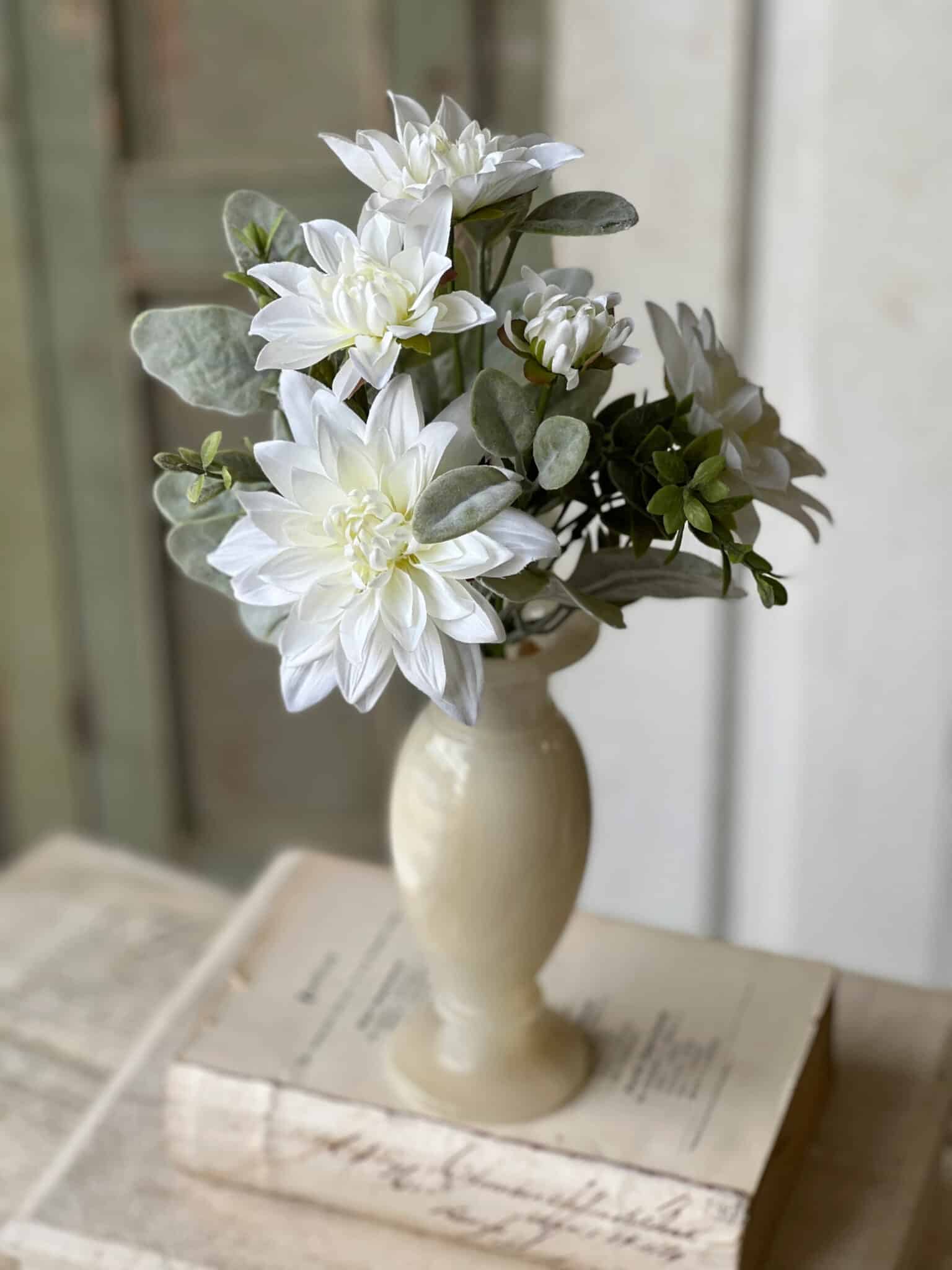 White Cottage Blooms Bundle in a ceramic vase styled on stacked vintage books.