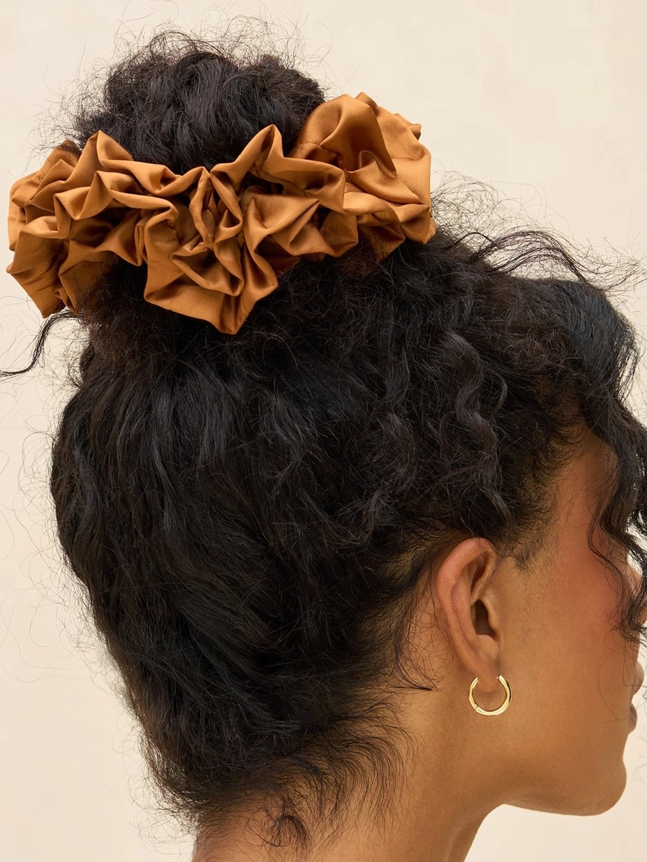 Model wearing a camel ruffle scrunchie in a high bun hairstyle.