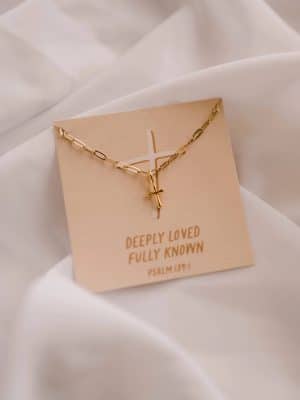Close-up of Deeply Loved Fully Known Charm Necklace displayed on cross artwork card