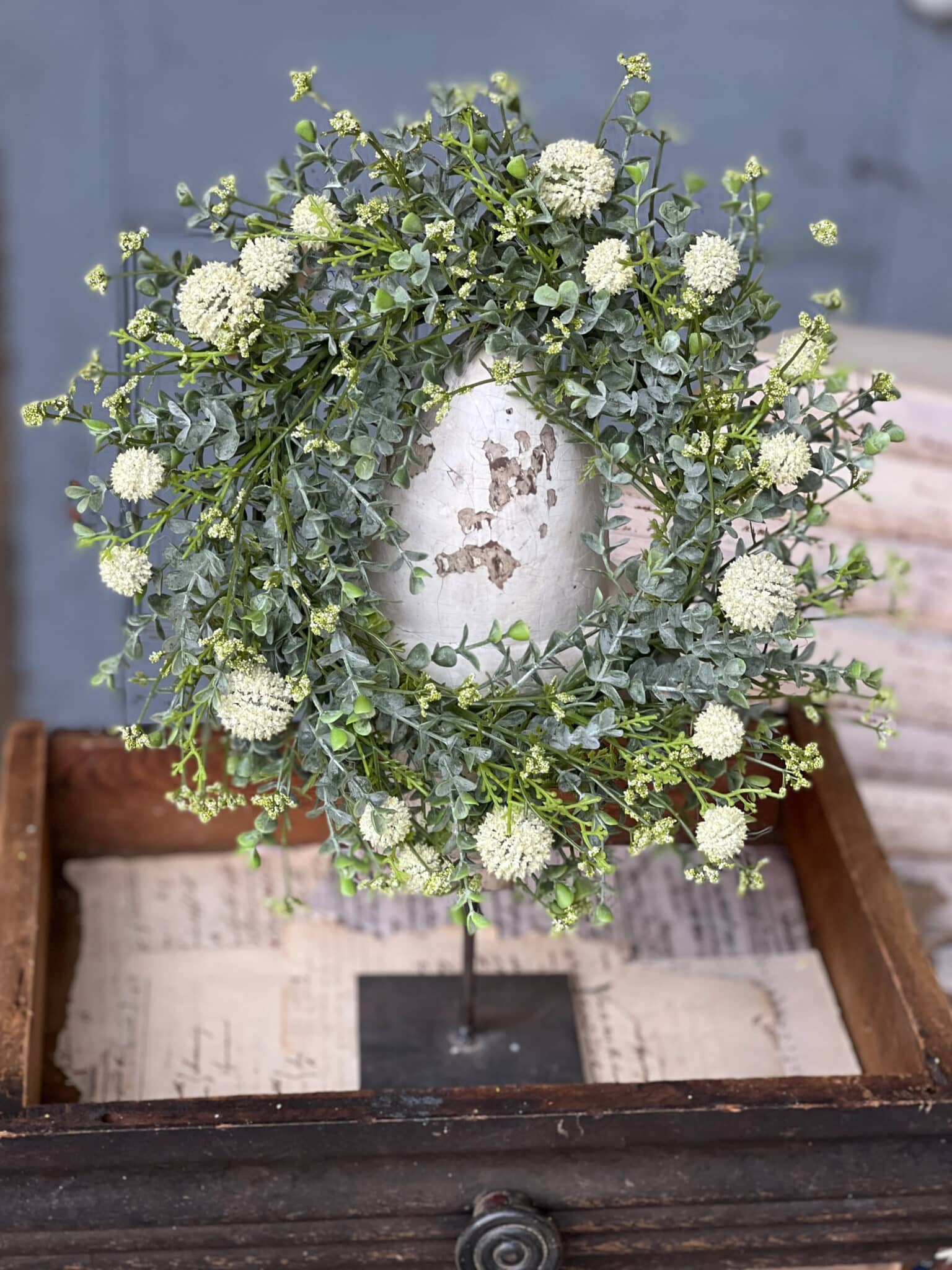 White Garden Allium Candle Ring displayed on a stand with petite white blooms and layered greenery.