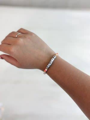 Single strand friendship bracelet with colorful beads and the word Bookish on wrist.