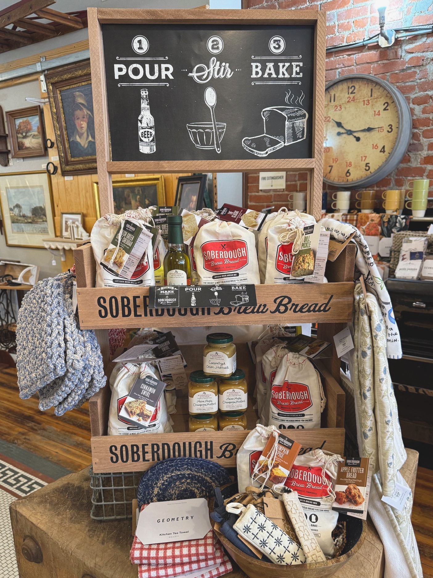 be-made-hays-ks-soberdough-beer-bread-mixes Display of Soberdough Beer Bread Mix bags arranged on wooden shelves with seasonal kitchen goods.
