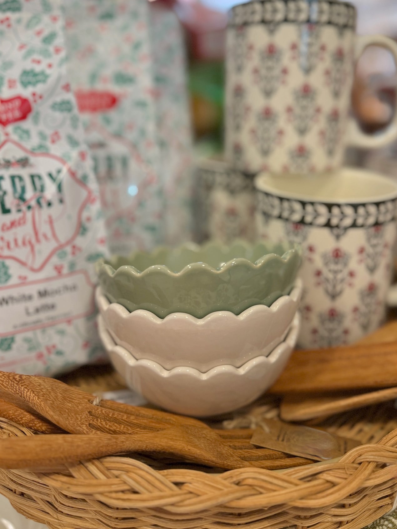 Stacked green and white scalloped stoneware bowls styled with holiday treats and gingerbread accents on a festive kitchen counter.