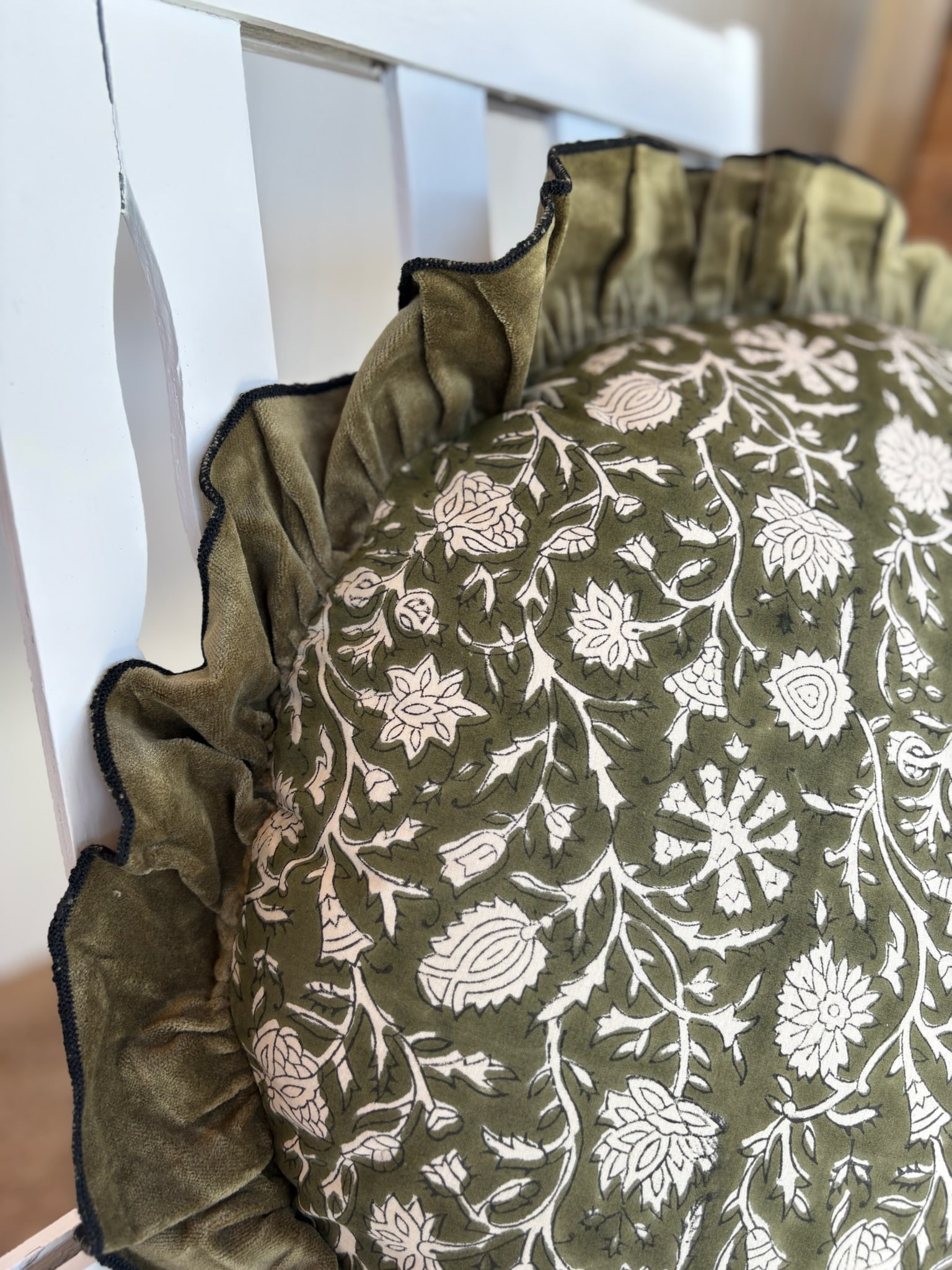 Close-up of the pillow’s gathered ruffle edge and block-printed floral design.
