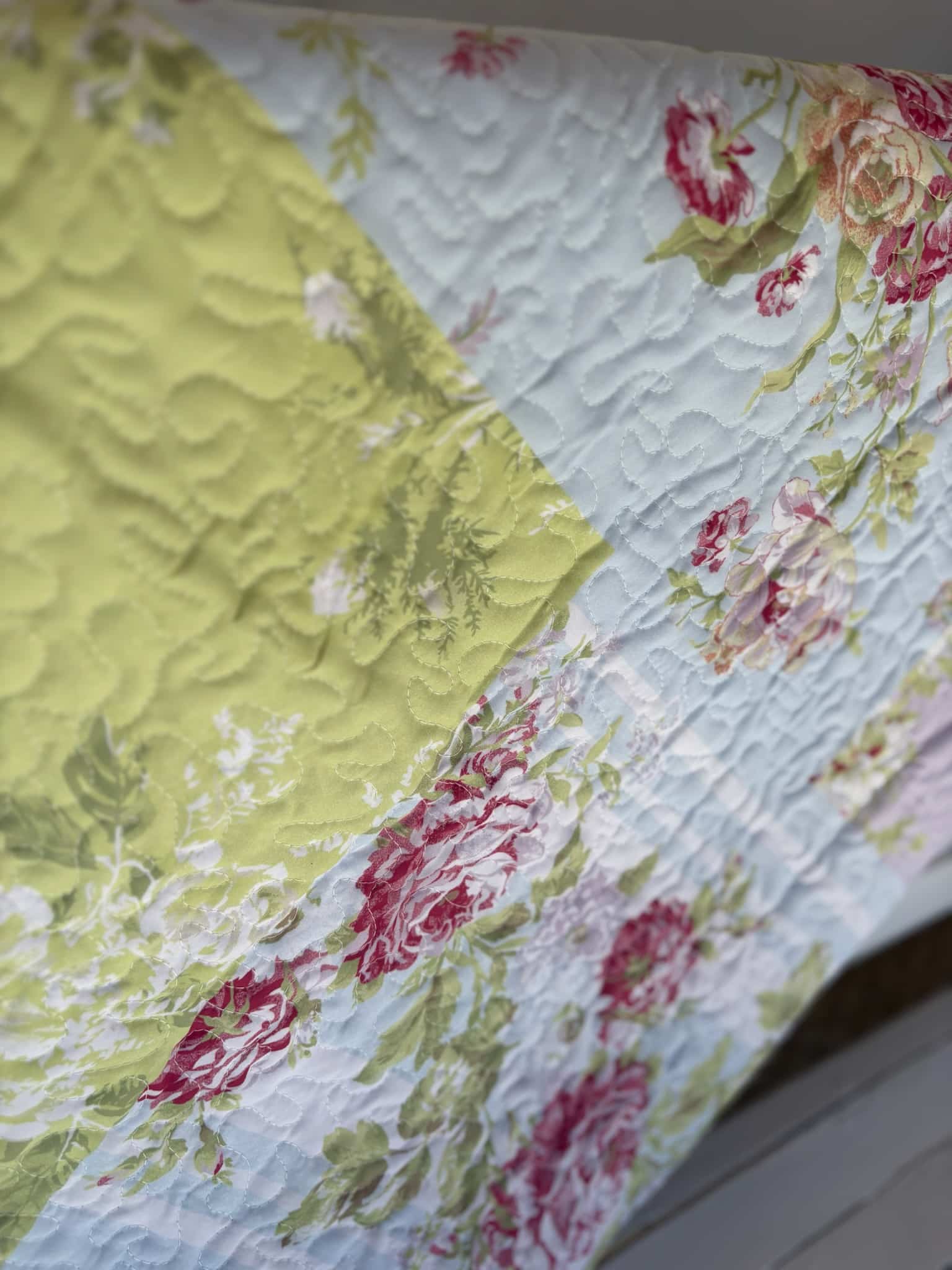 Close-up of the Flower Market Quilt Throw Blanket showing yellow and rose floral patchwork and quilted stitching.