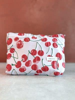 Front view of the Red Cherry Makeup Bag, highlighting the playful cherry print and stitched label detail.