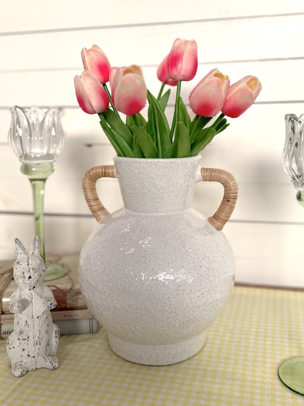 Bright Pink Tulip Bundle in the Rattan Wrapped Handle Vase Medium styled with a distressed bunny figurine and candle holders.
