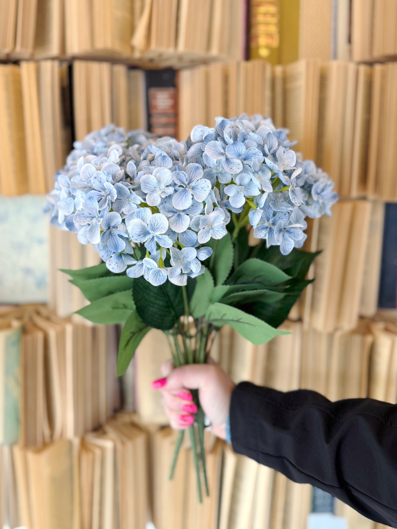 Handheld bundle of faux light blue hydrangeas showing abundant blooms for a full floral arrangement.