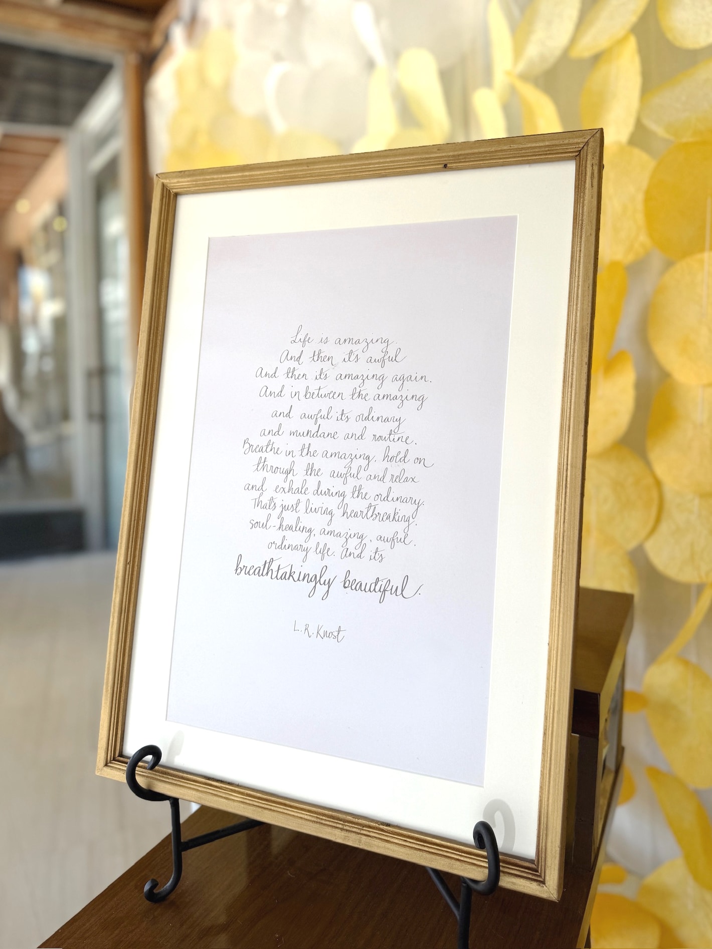 Inspirational wall art print with L.R. Knost quote in script, framed in gold and displayed on tabletop easel.