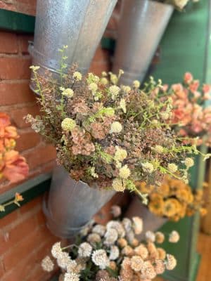 Neutral faux floral stem with cream blooms and wispy greenery