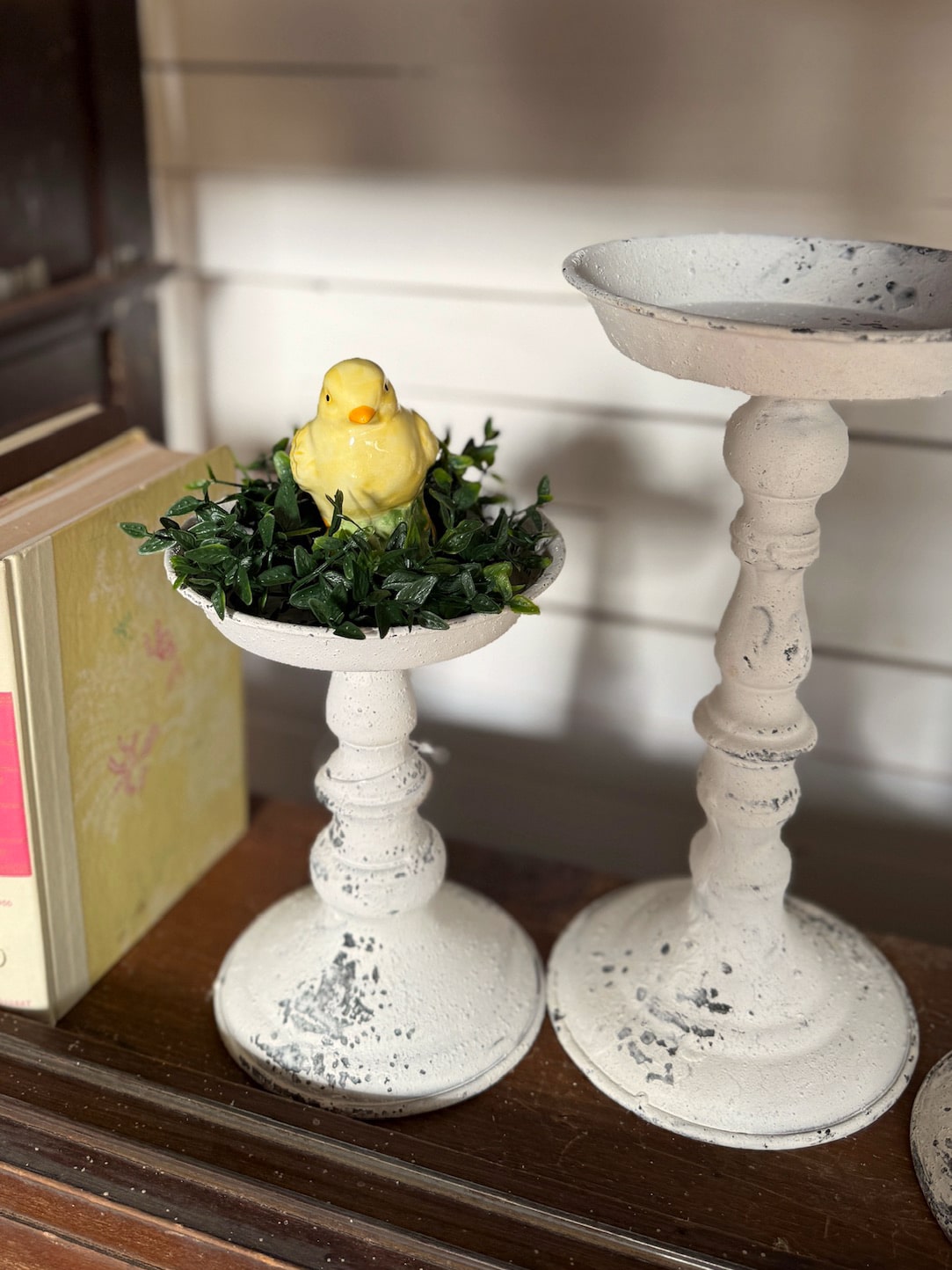 Distressed pillar candle holders styled with spring chick decor.
