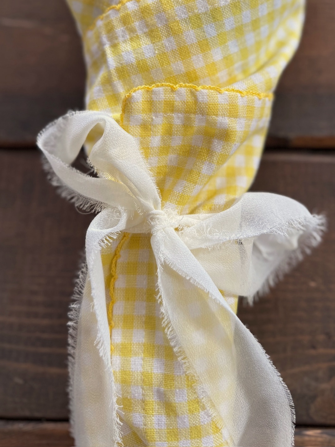 Yellow gingham bouquet wrapped with soft hand-torn chiffon ribbon tied in a bow for gift styling
