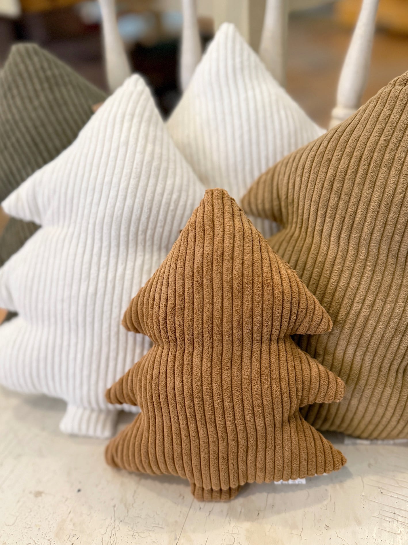 Small Camel Corduroy Stuffed Tree pillows displayed among white, green, and cookie-brown corduroy trees, adding cozy neutral texture to holiday décor.