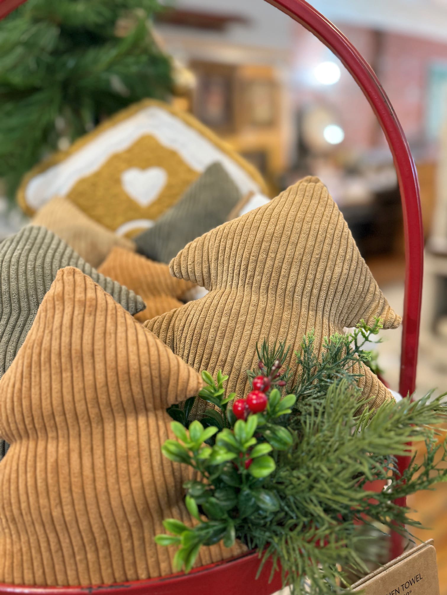 Large Cookie Corduroy Stuffed Trees arranged in a festive red basket with greenery and berries for cozy Christmas styling.