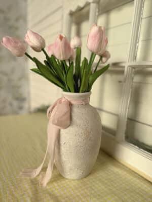 Rustic White Ceramic Vase With Worn Finish Filled With Pink Tulips and Tied With Sheer Ribbon