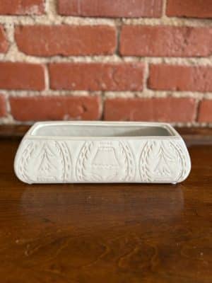 Low rectangular stoneware planter featuring a debossed floral pattern and unique white reactive glaze.