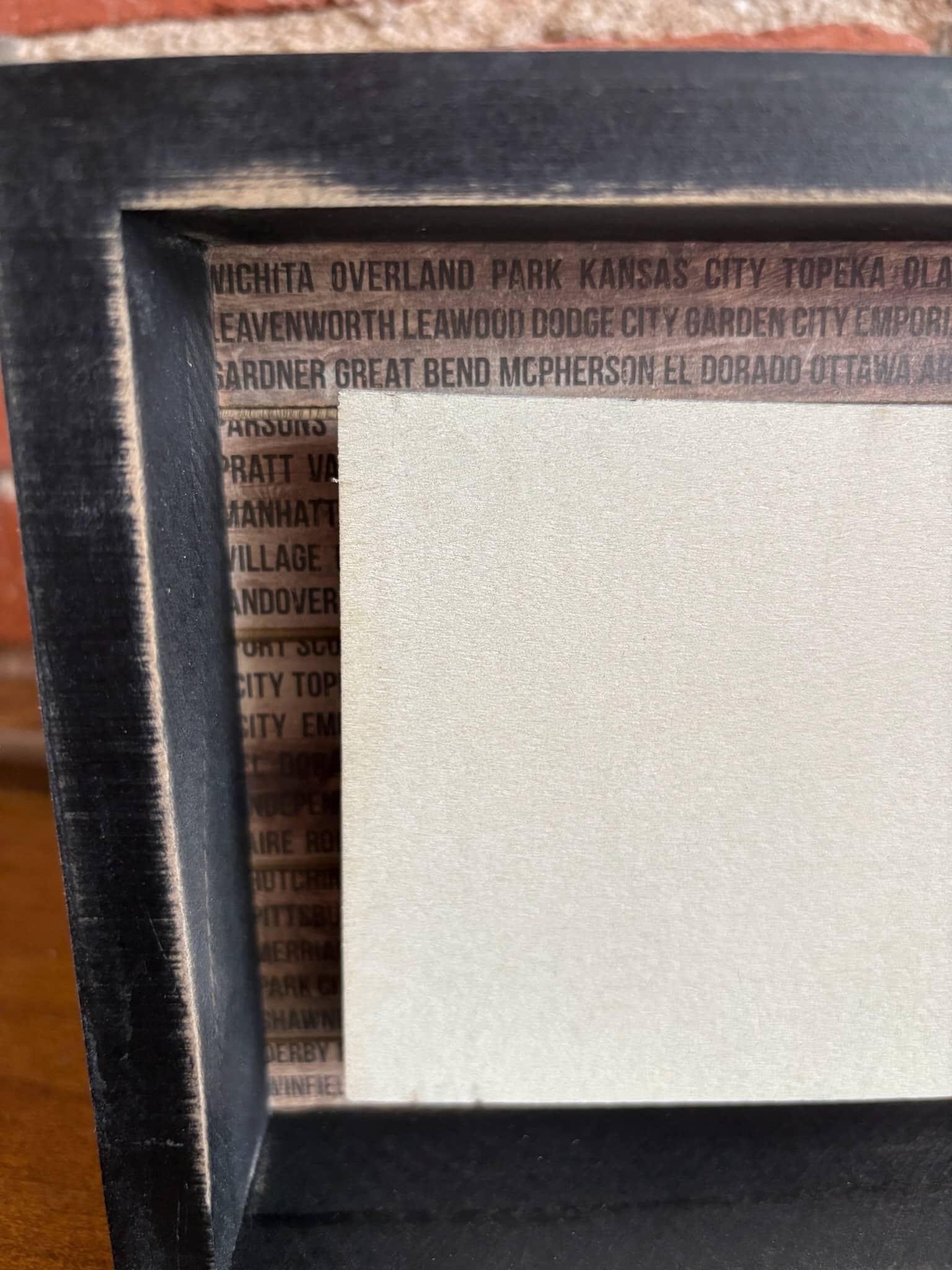 Wooden box sign with Kansas cutout and graphic state details.