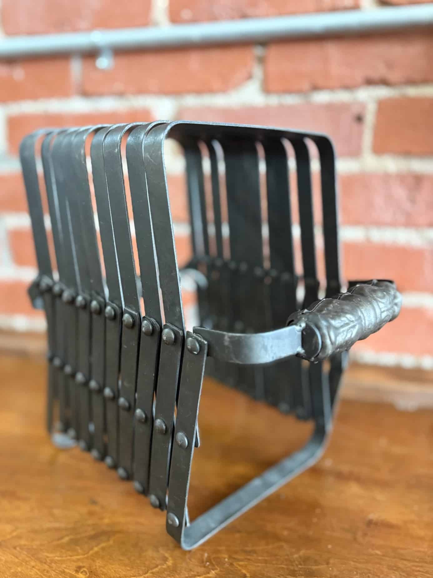 Sturdy accordion organizer made of black metal, positioned vertically for compact storage options.