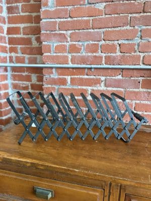 Side view of black accordion-style metal organizer with rivet detailing, compact and sturdy design.