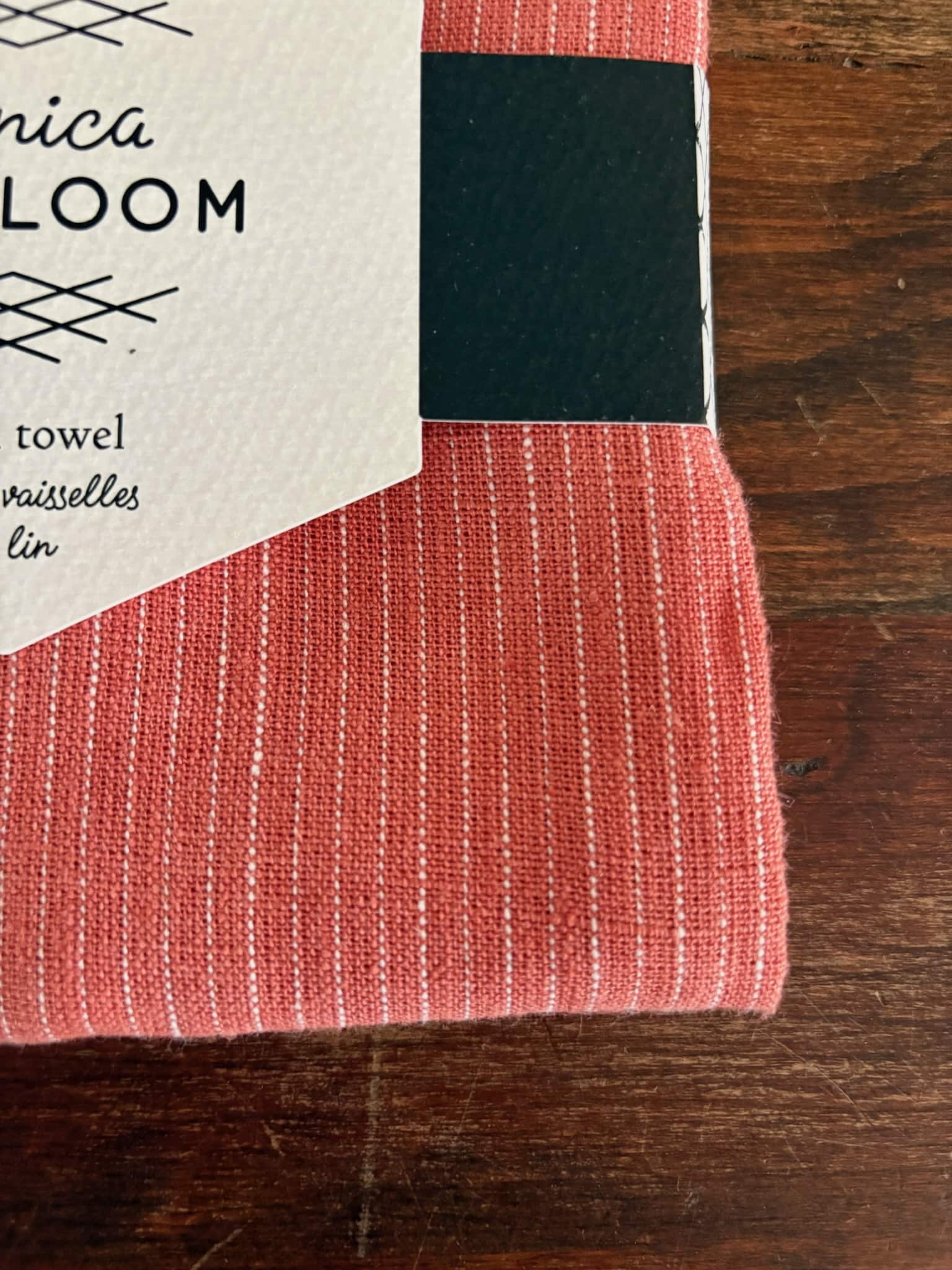 Clay-colored heirloom linen dish towel with stitched white stripe.