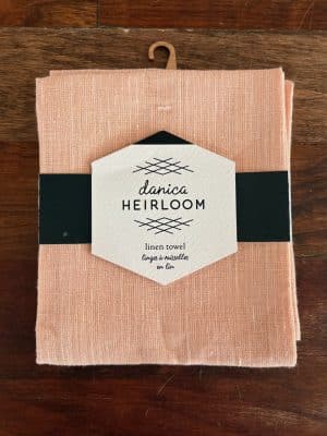 Folded blush linen dish towel with stitched stripe, part of the Heirloom Linen collection.