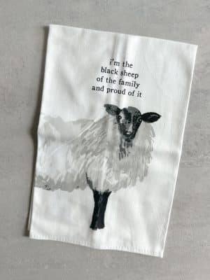 Cotton tea towel with a watercolor-style black sheep illustration and the phrase “I’m the black sheep of the family and proud of it.”