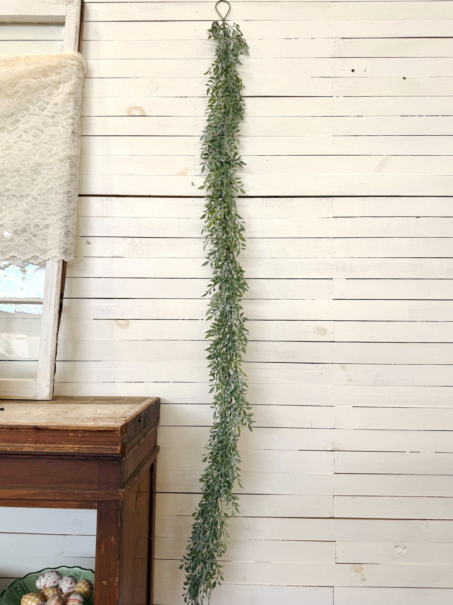 Six-foot soft green tea leaf garland displayed vertically to show length.