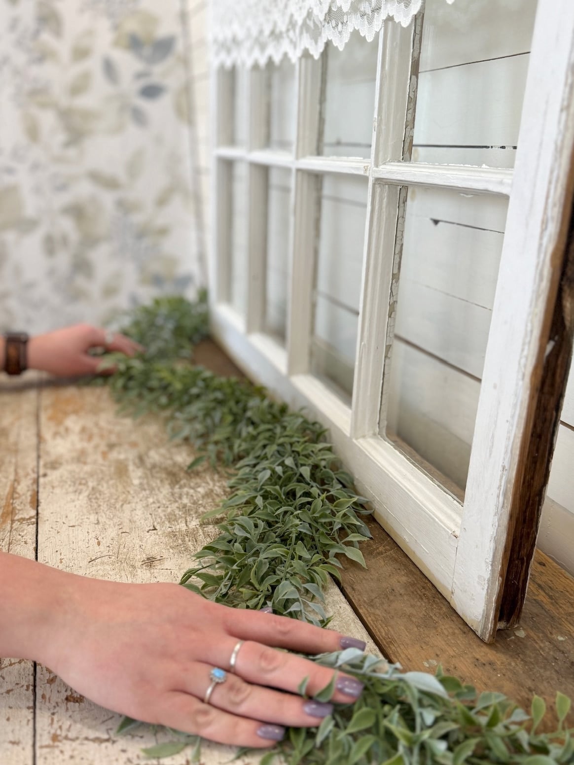Flexible tea leaf garland being styled along a window ledge.