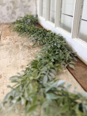 Close view of soft green tea leaf garland showing layered leaves and realistic texture.