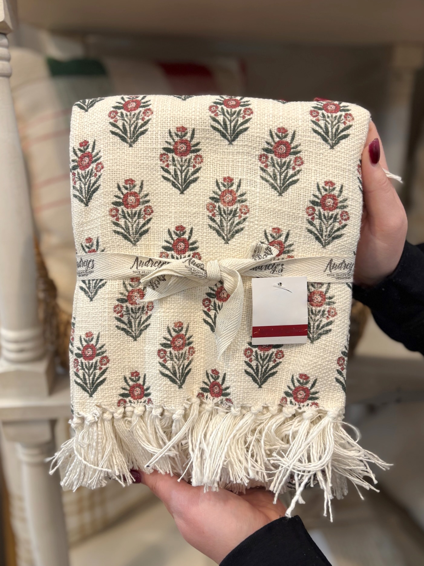 Red block print floral throw blanket with fringe and fabric tie.