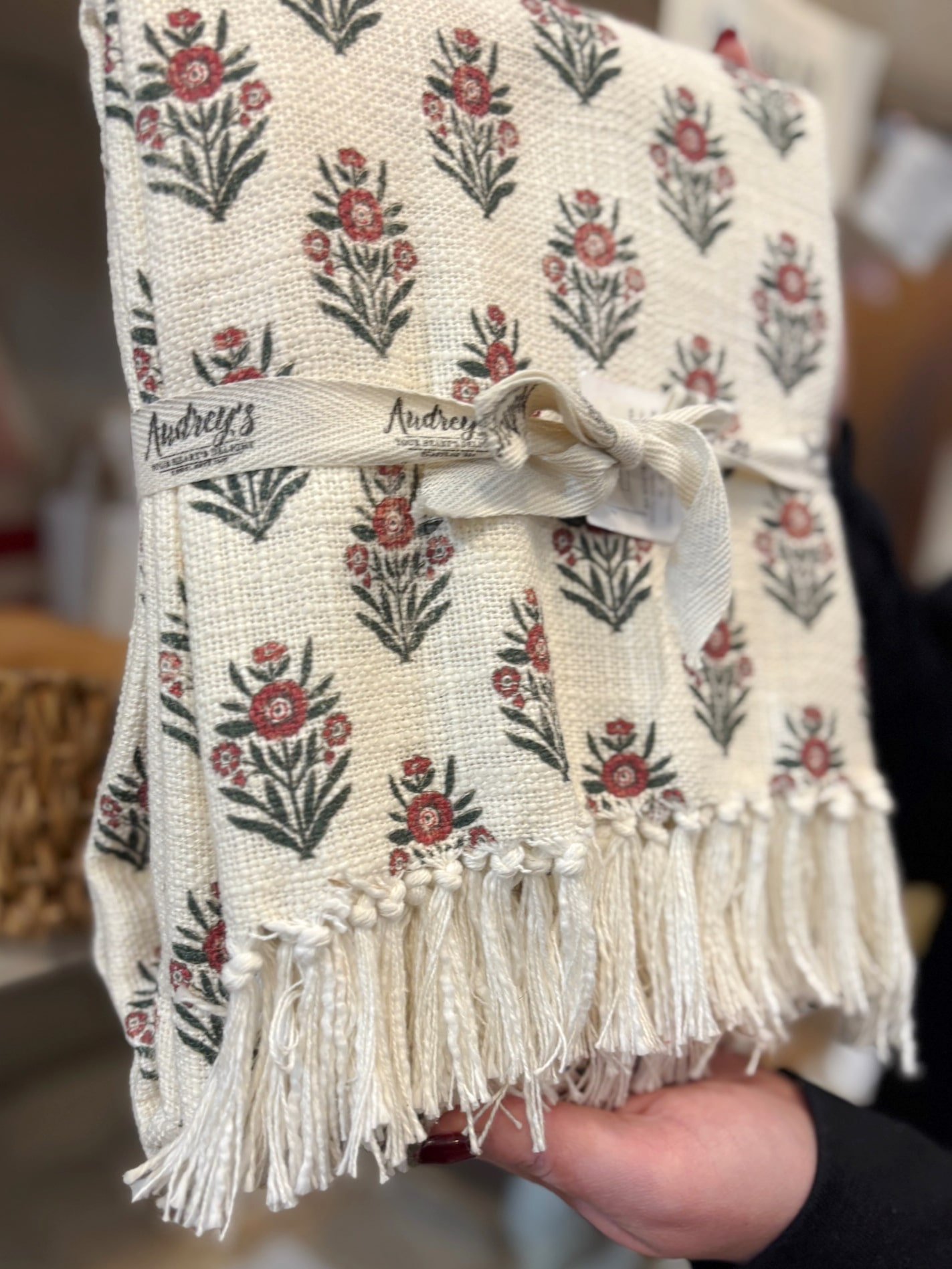 Close-up of red block print floral throw blanket showing fringe detail.