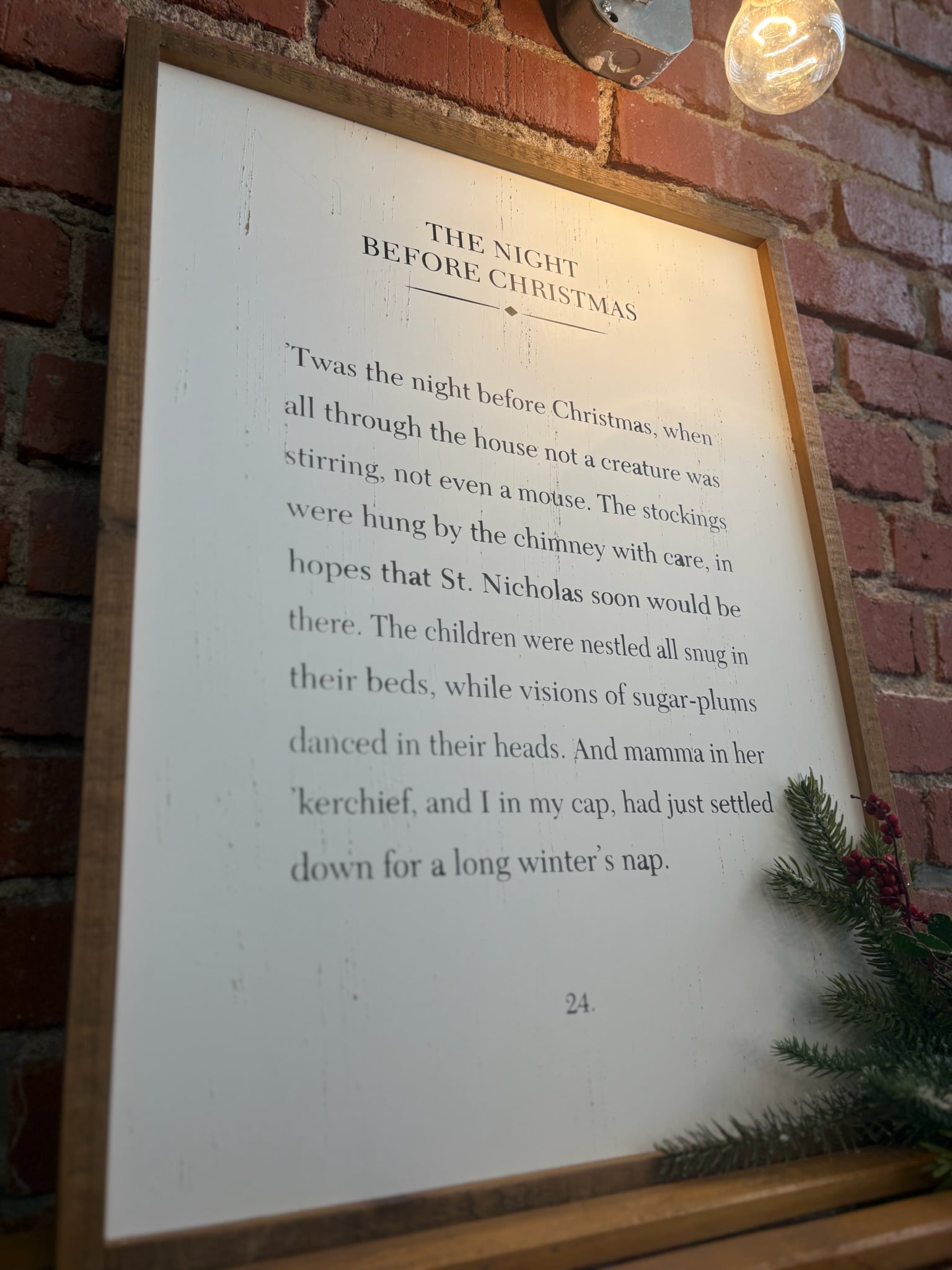 Close-up of The Night Before Christmas Sign against a brick wall.