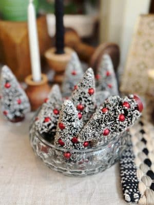 Mini Frosted Bottlebrush Trees with red ornaments and snowy white tips displayed in a glass bowl for a festive holiday accent.