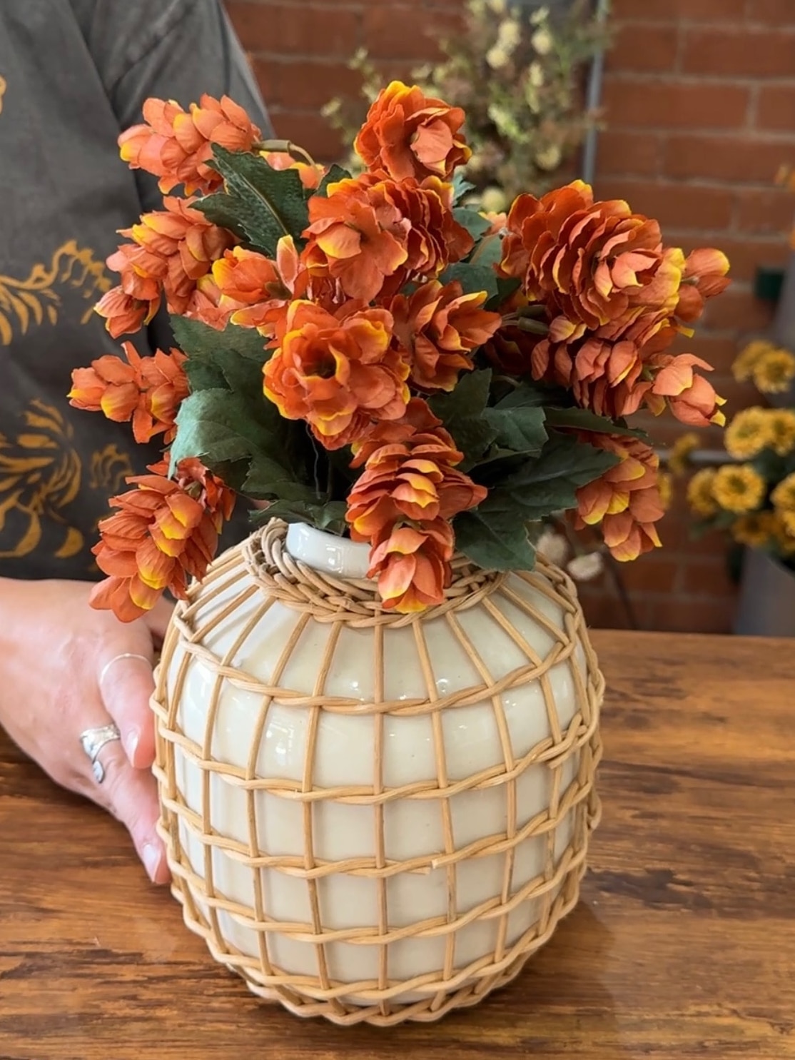 Orange Hops Bush displayed in a rattan-wrapped vase.