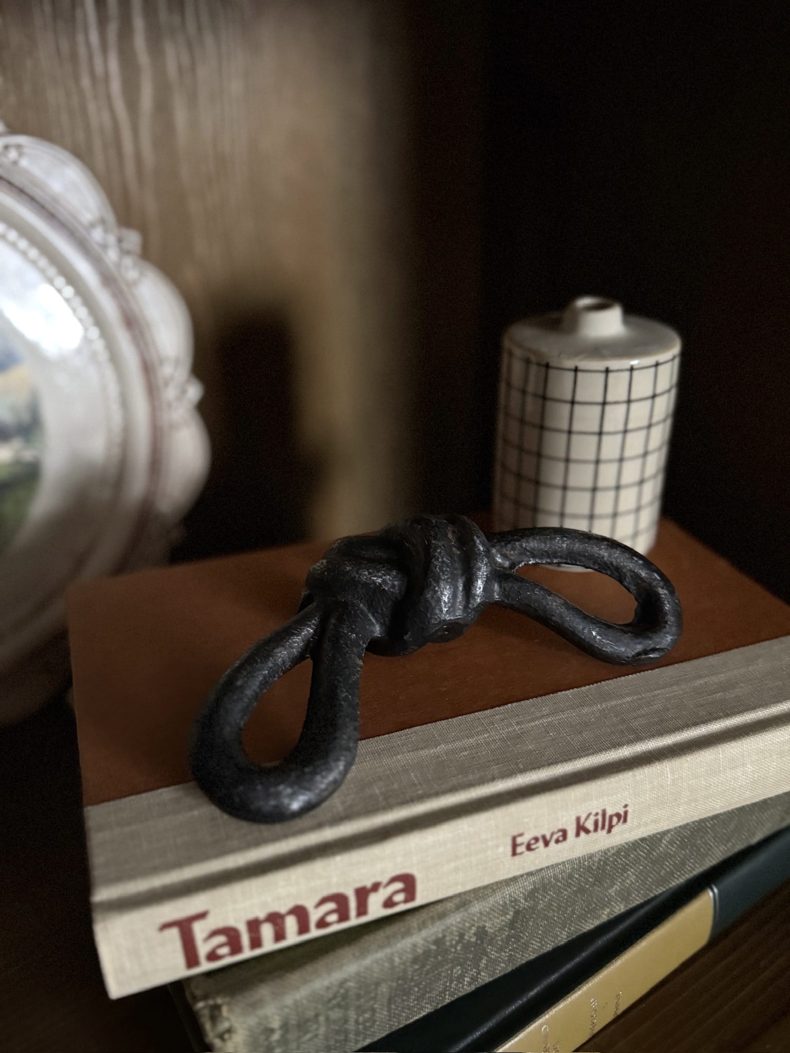Cast iron sailor knot styled on a stack of books.