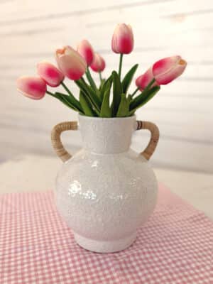 Bright Pink Tulip Bundle arranged in the Rattan Wrapped Handle Vase Medium on a pink gingham table runner.