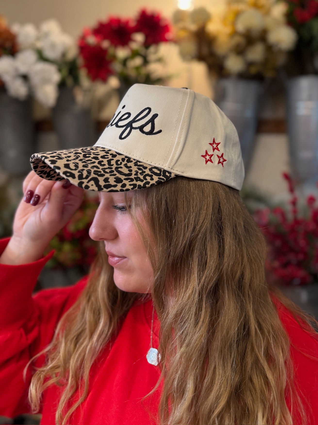 Close-up of Chiefs embroidered trucker hat with leopard bill and red star stitching on the side.