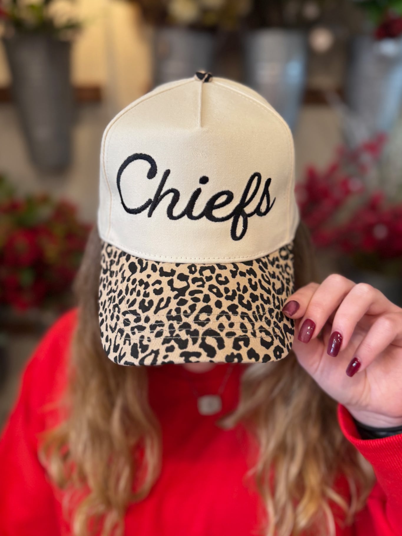 Natural Chiefs trucker hat with black embroidery and leopard-print bill, worn by model.
