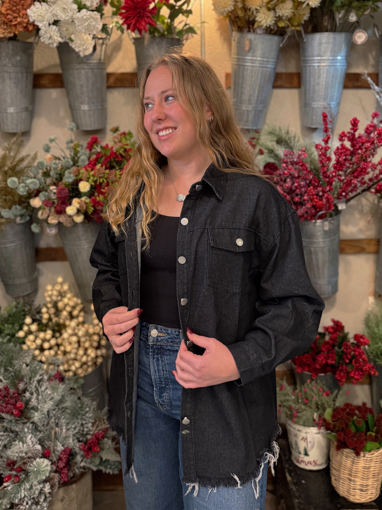 Loose-fit black denim jacket worn open over a simple black top, perfect for everyday layering.