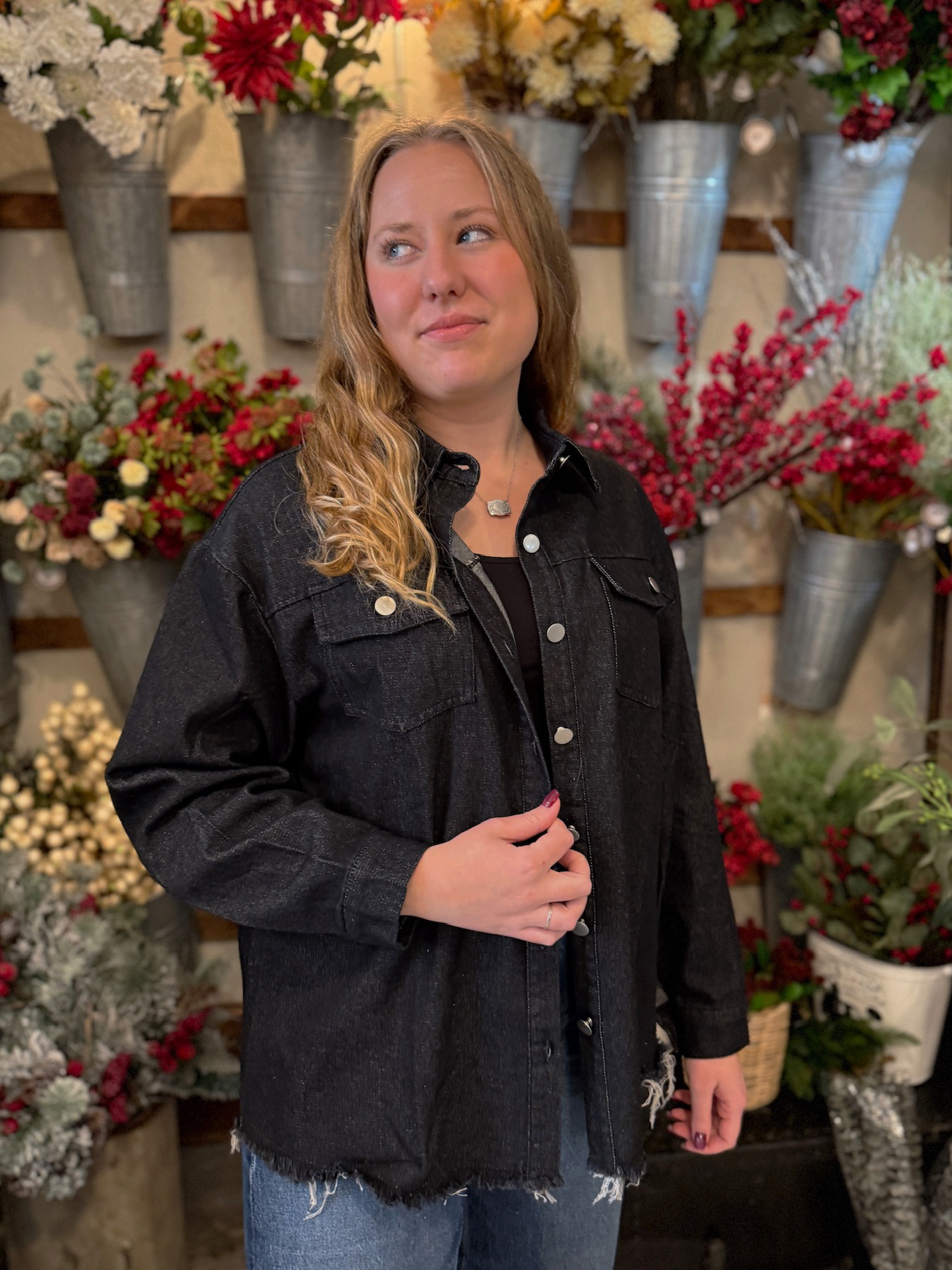 Washed black jean jacket with chest pockets and long sleeves, styled casually with denim jeans.