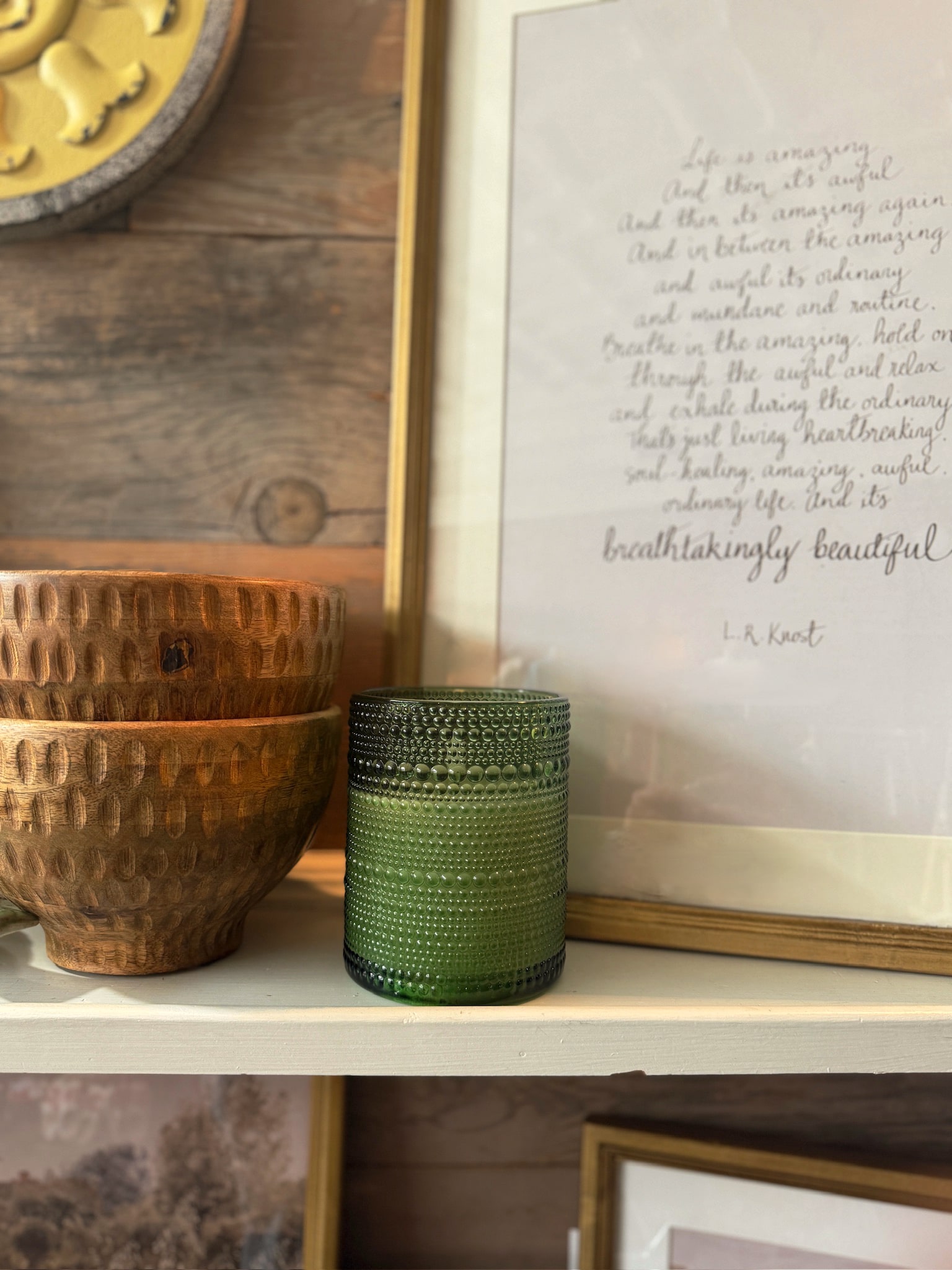 Gold framed inspirational quote print by L.R. Knost styled on a shelf with wood bowls and decor accents.