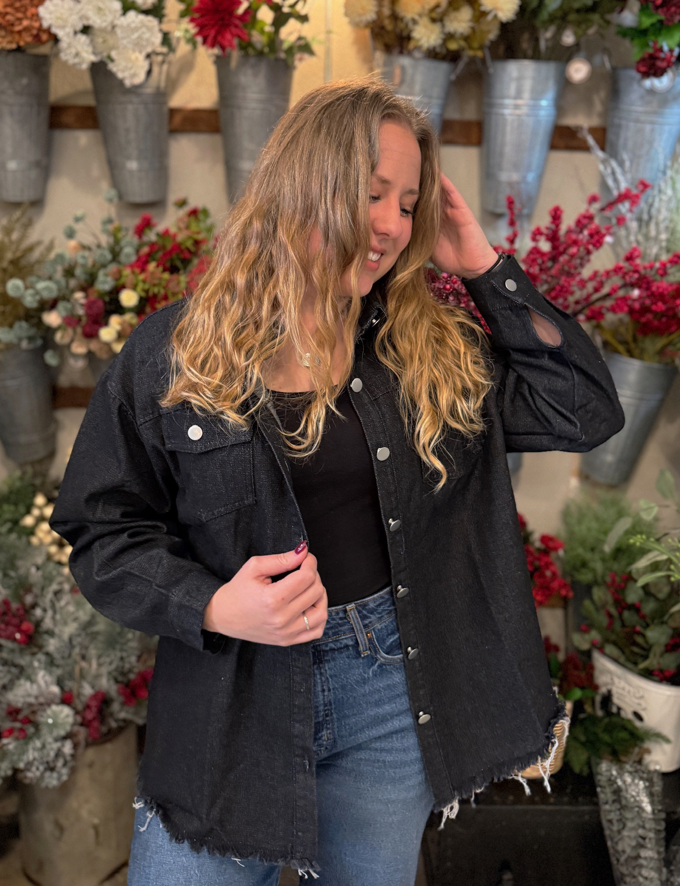 be-made-hays-ks-black-denim-frayed-hem-jacket Black denim jacket with drop shoulders and raw frayed hem, shown buttoned at the front.