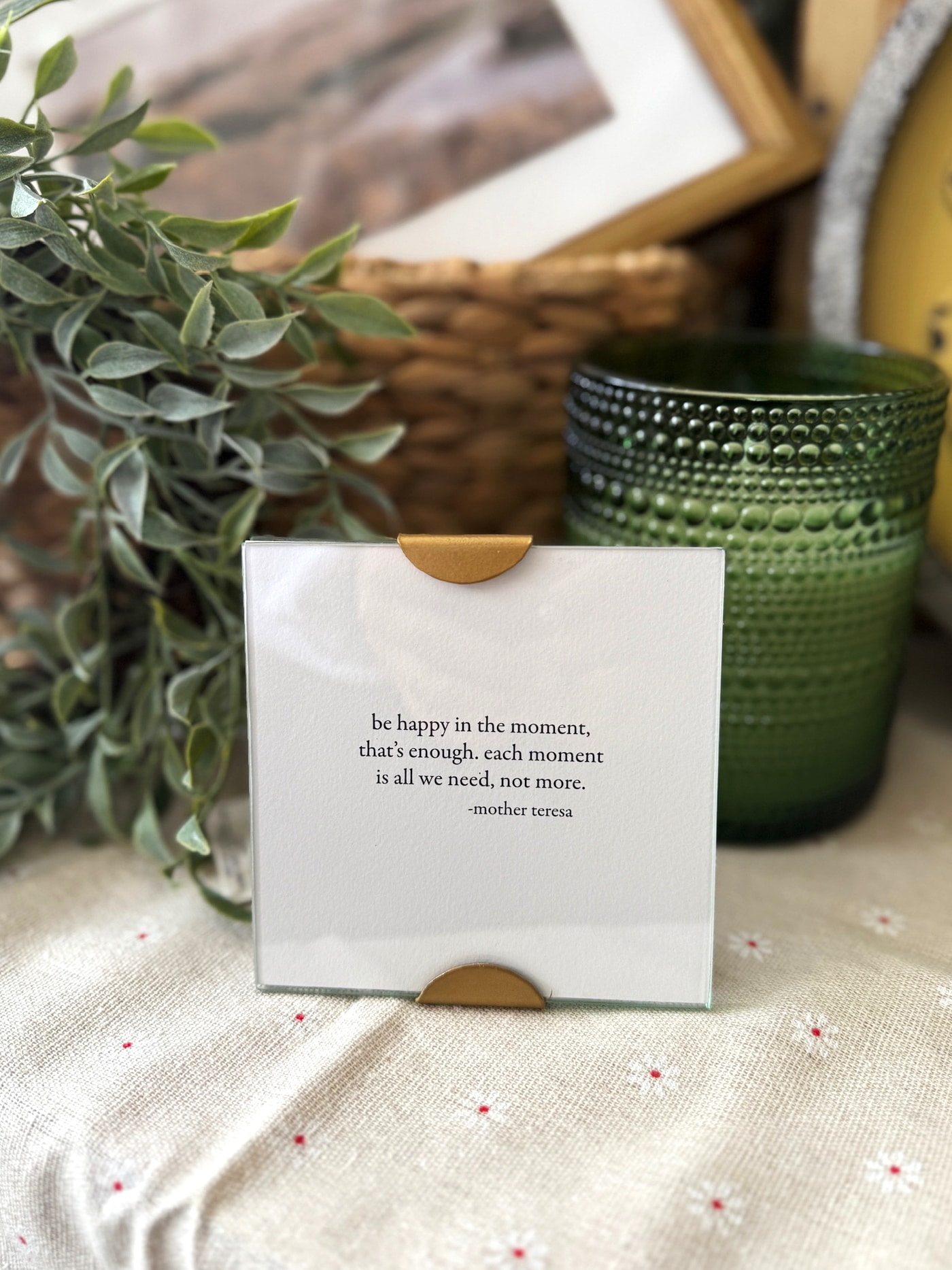 Glass scallop frame with gold corners featuring Mother Teresa quote about being happy in the moment