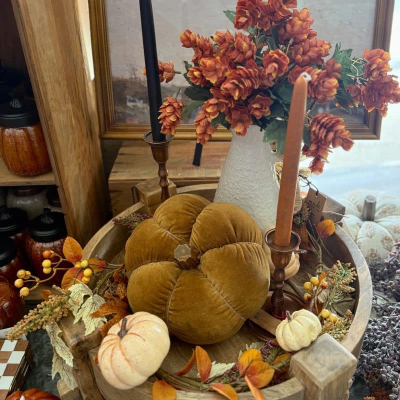 Wood chakki table pedestal styled with velvet pumpkins, fall garland, and taper candles.